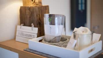 A hotel reception area with a welcome sign, a glass candle holder, and a wicker tray.