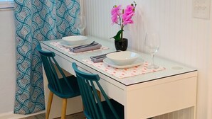 A dining table with two chairs, a vase with flowers, and a wine glass. - An oasis ACROSS THE STREET FROM THE BEACH :) (Treasure Island)