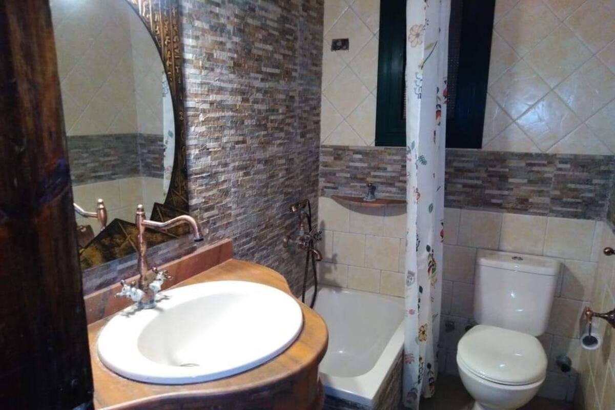 Ein Badezimmer mit runder Waschbecken, Badewanne und Toilette.