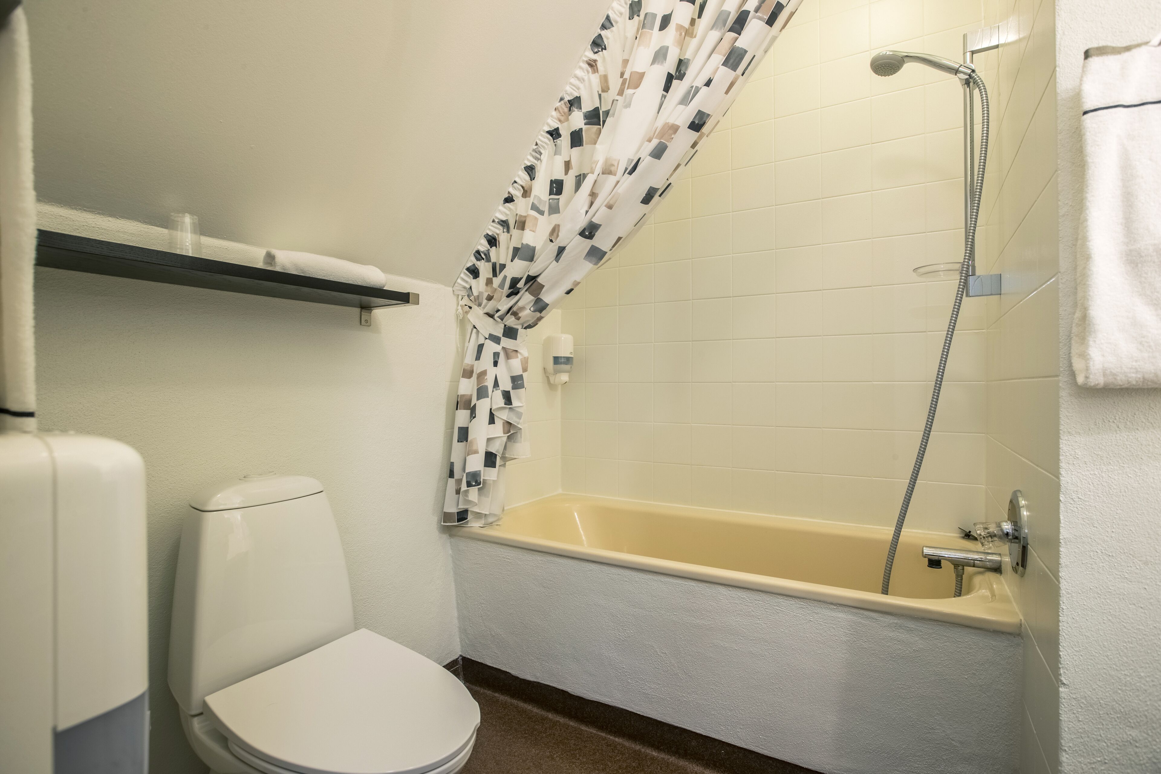 A bathroom with a toilet, a bathtub, and a shower.
