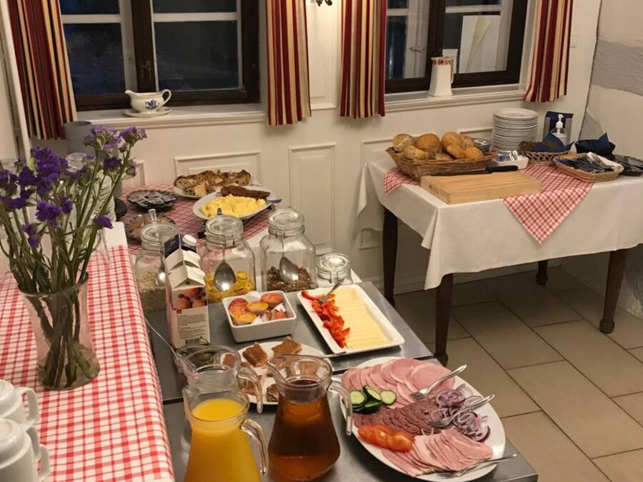 A breakfast buffet with various food items, a fruit bowl, and a coffee station.