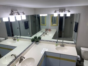 Een bad/douchecombinatie, een haardroger, handdoeken, zeep