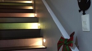 A staircase with a handrail and a wall-mounted light switch. - Scenarium Hotel (Jaboatão dos Guararapes)