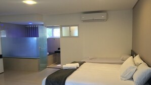 A modern hotel room with a large bed, a separate bathroom, and a small sitting area. - Scenarium Hotel (Jaboatão dos Guararapes)