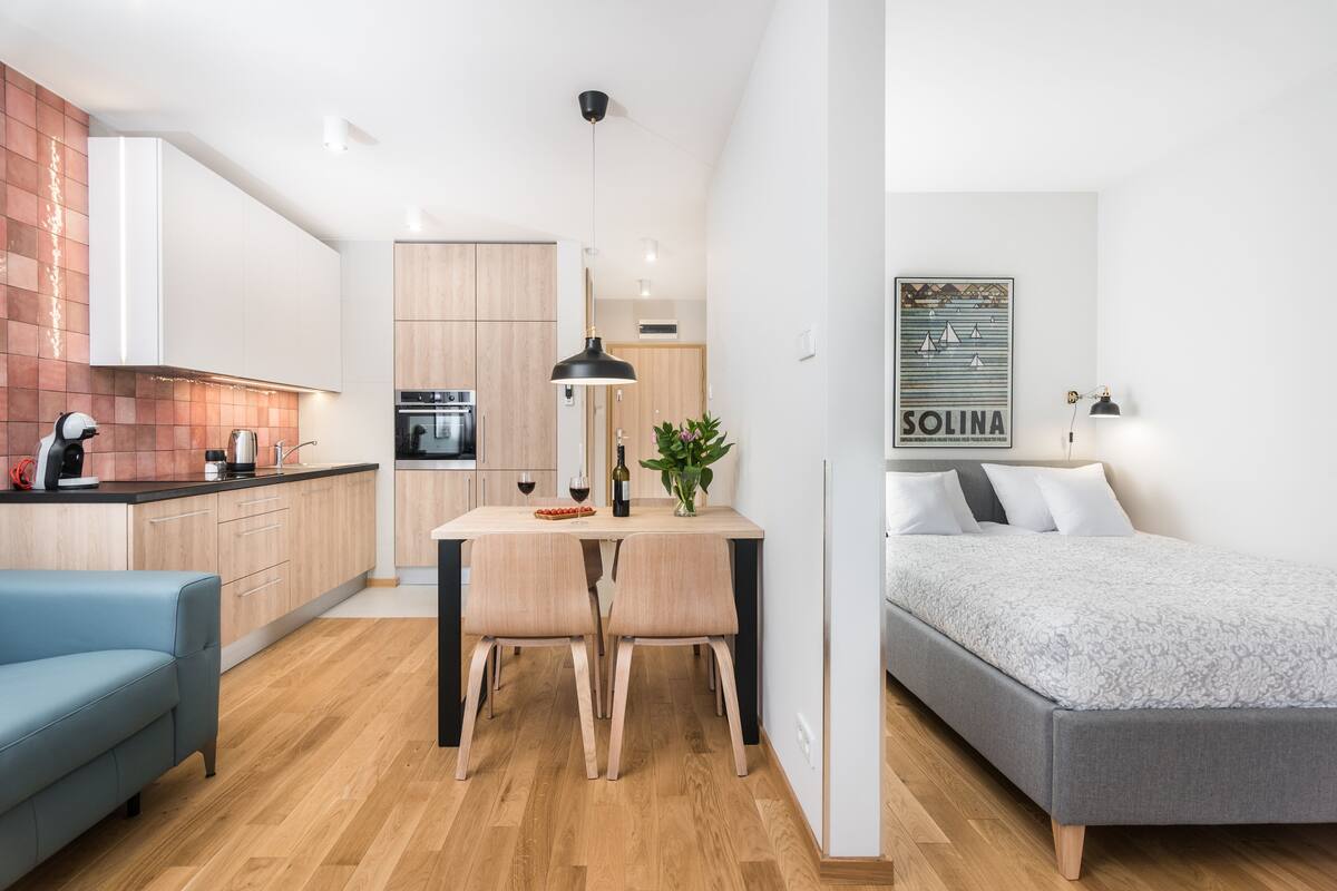 A compact living space with a kitchenette, a dining area, and a bedroom.