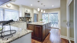 Una cocina con encimeras de granito, electrodomésticos de acero inoxidable y una isla grande.