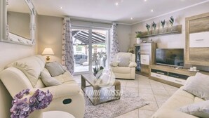 A modern living room with a sofa set, a coffee table, a TV, and a large window. - Villa Sonja is located directly on the sea (Medulin)