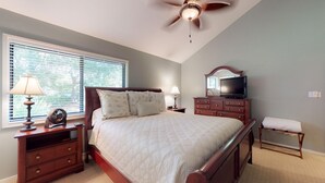 A bedroom with a bed, nightstands, a dresser, a television, a ceiling fan, and a window with blinds. - Fantastic Fazio Villa with Golf Course View! (Hilton Head)