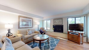 A modern living room with a sofa, coffee table, and fireplace. - Fantastic Fazio Villa with Golf Course View! (Hilton Head)