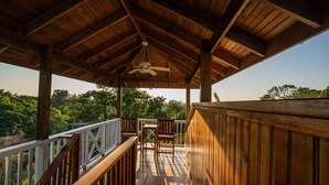 Eine Holzterrasse mit Deckenventilator, Tisch und Stühlen.