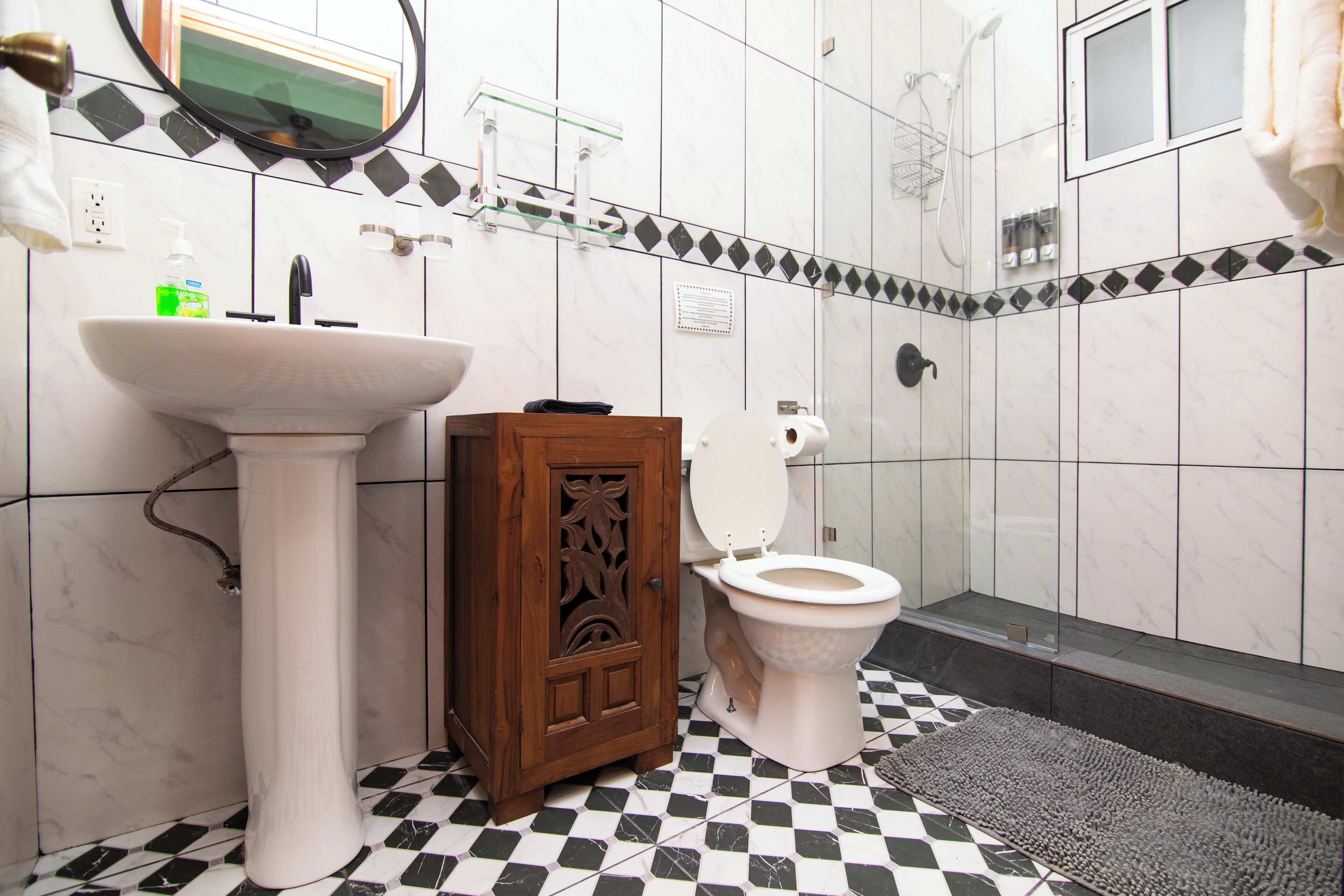 Une salle de bain avec un lavabo blanc, un meuble en bois et des toilettes.