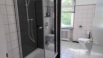 Ein modernes Badezimmer mit Duschkabine, Toilette und Waschbecken.