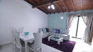 Una sala moderna con comedor, un conjunto de sofá y una alfombra morada.