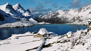 Un paysage montagneux enneigé avec un lac bleu limpide.