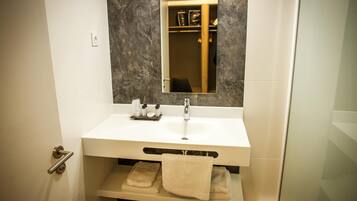Une salle de bain avec un lavabo blanc, un miroir et un porte-serviettes.