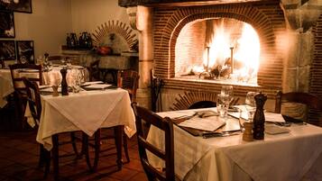 Un restaurante con paredes de ladrillo, chimenea y mesas dispuestas para comer.