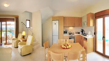 A modern kitchen with wooden cabinets, a dining table with chairs, a refrigerator, and a microwave.