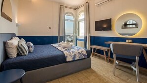 A bedroom with a bed, a desk, a chair, and a TV. - Duplex Gerakini Apartment with Pool (Gerakini)