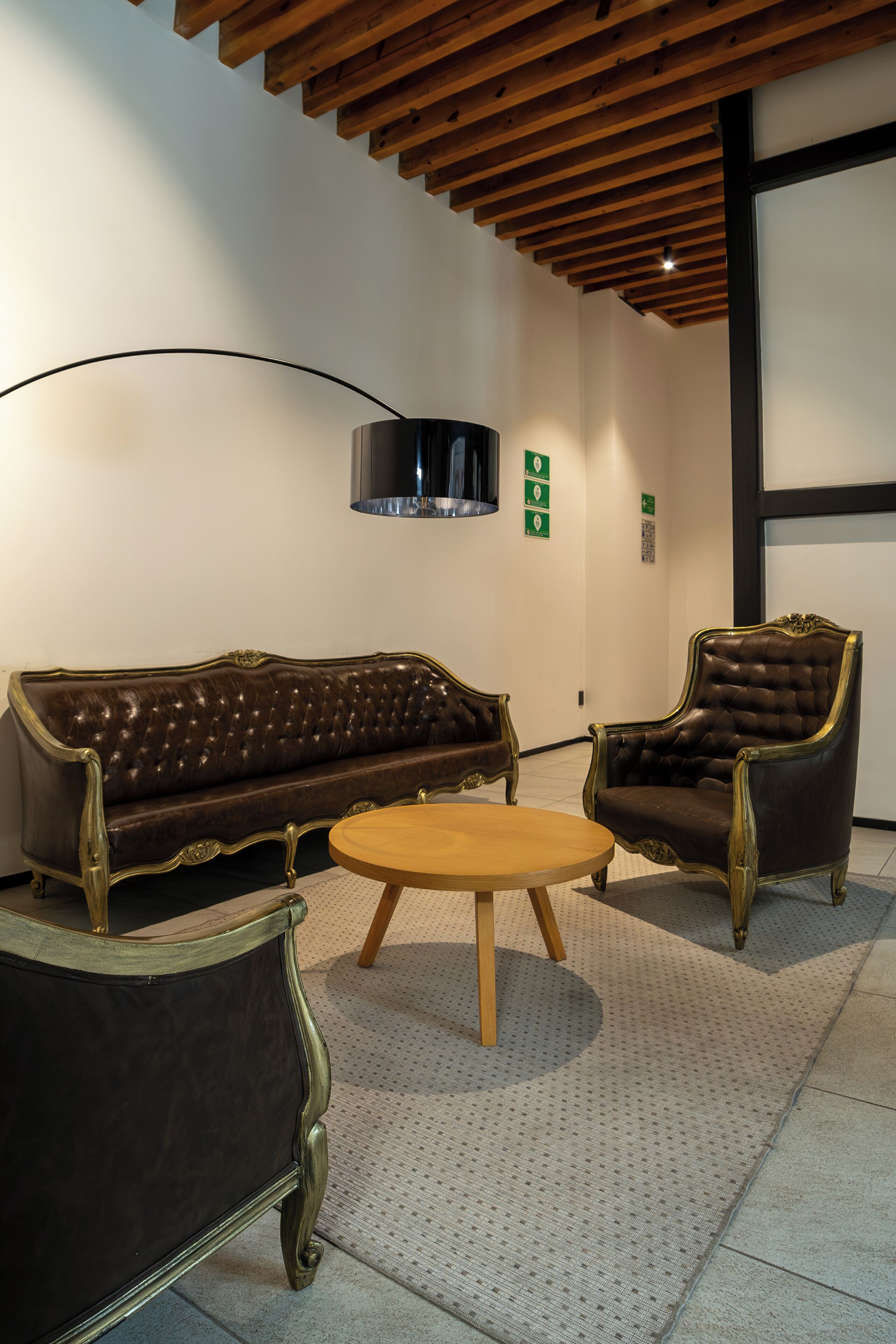 A room with a dark brown leather sofa, a matching armchair, and a wooden coffee table.