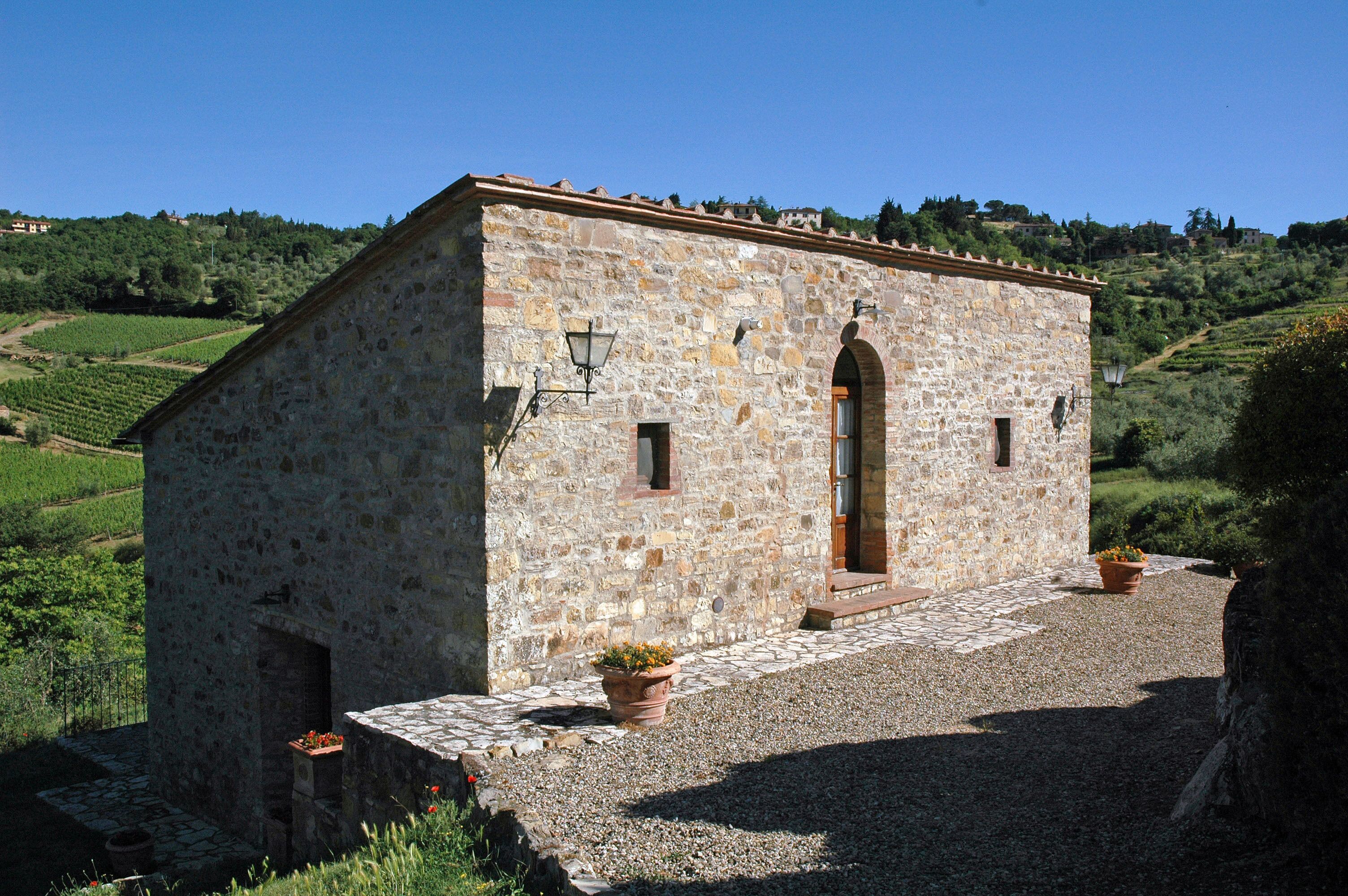 A stone building with a small porch, a single door, and two windows.