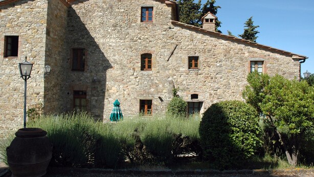 Un edificio in pietra con diverse finestre e un camino.