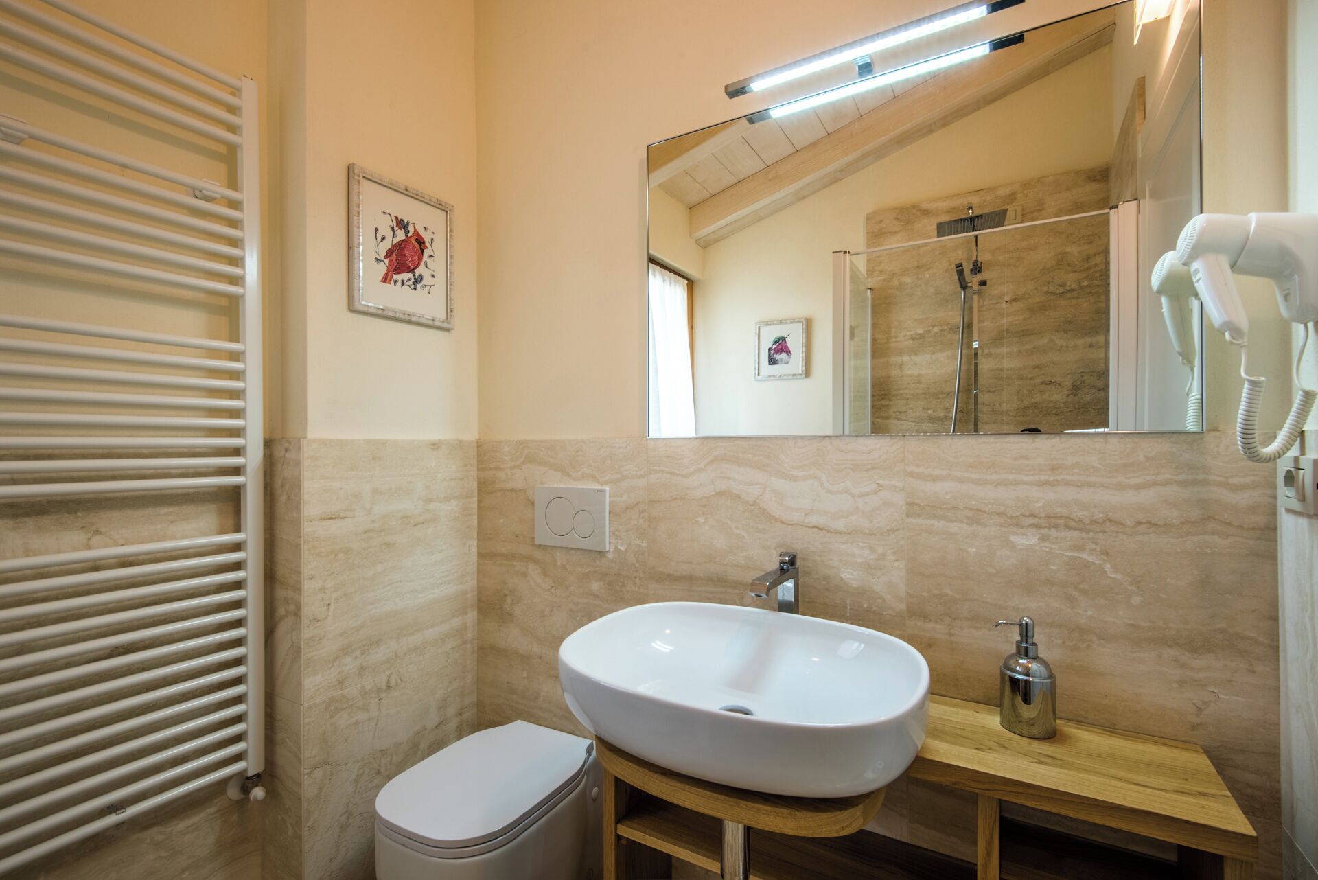 A bathroom with a white sink, a mirror, a towel rack, and a toilet.