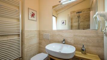 A bathroom with a white sink, a mirror, a towel rack, and a toilet.