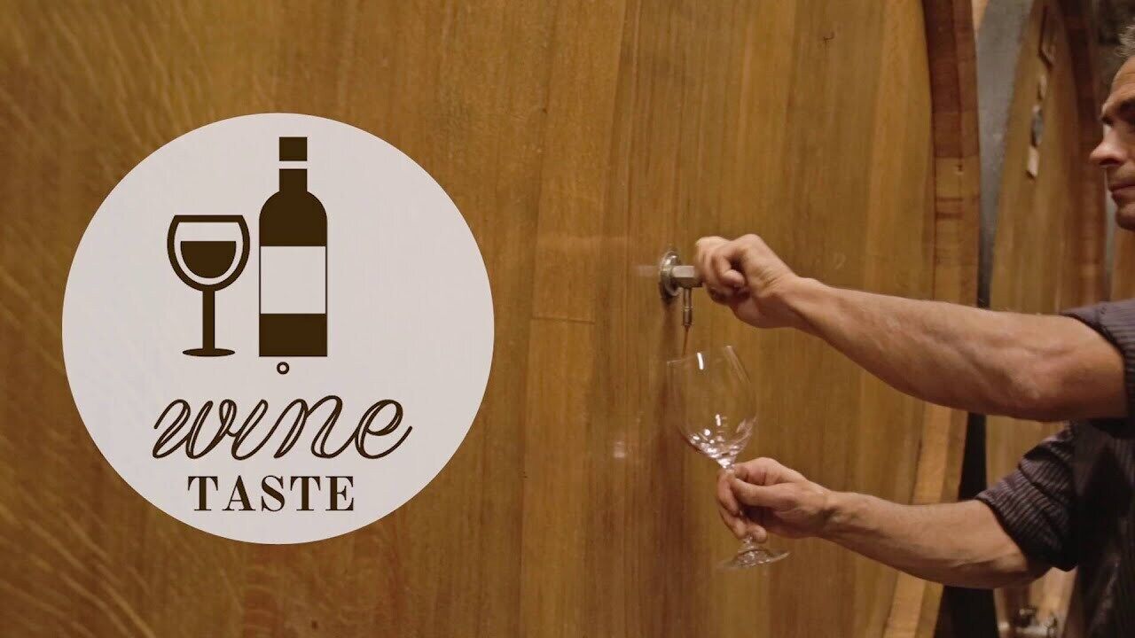 Une personne qui verse du vin d’une bouteille dans un verre.