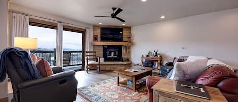A living room with a fireplace, a sofa, a coffee table, and a TV.