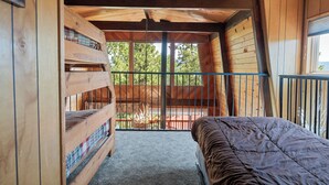 Eine Hütte mit Schlafgalerie, ausgestattet mit einem Etagenbett und einem Einzelbett.