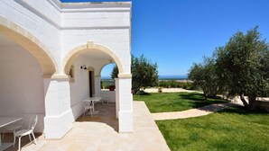 A white building with arches and a patio area. - Masseria Spetterrata (Fasano)