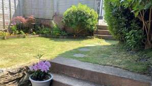 A garden with a stone staircase leading up to a house. - Whortleberry Studio B&B (Minehead)