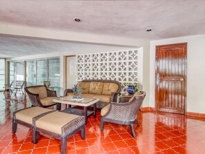 A room with a sofa, two armchairs, a coffee table, and a decorative wall panel. - Hotel San Carlos (Tizimín)