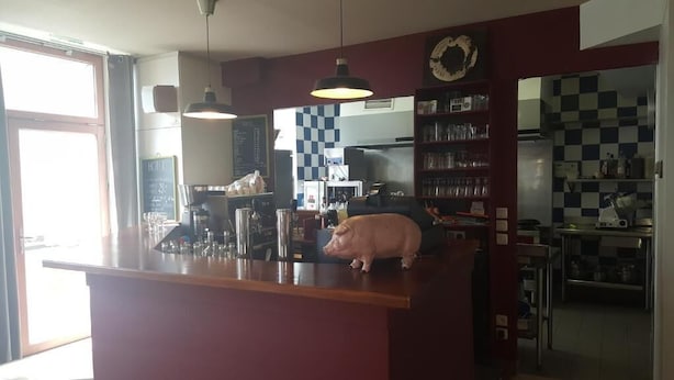 Una cucina con uno schienale a scacchi, un salvadanaio sul bancone e un menù su una lavagna.