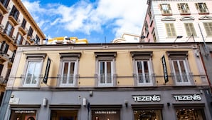 A building with storefronts labeled "TEZENIS" and "intimissimi". - Prestige Rooms Chiaia (Naples)