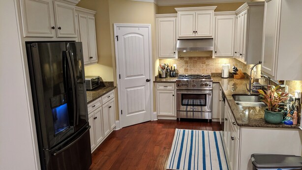 A kitchen with white cabinets, a stainless steel refrigerator, a stove, and a sink. - Master's Rental - House, Walking distance to Smokehouse BBQ and a coffee shop (Augusta)