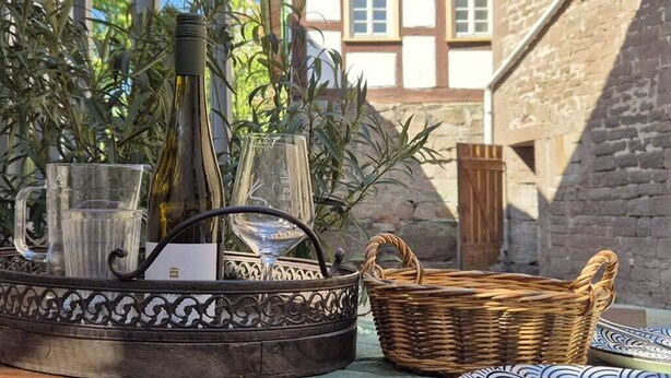 A table with a metal tray holding wine bottles, glasses, and a basket.
