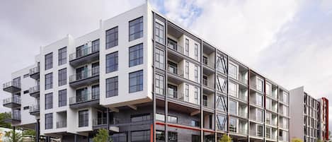 Un edificio de varios pisos con balcones, ventanas amplias y un diseño arquitectónico moderno.