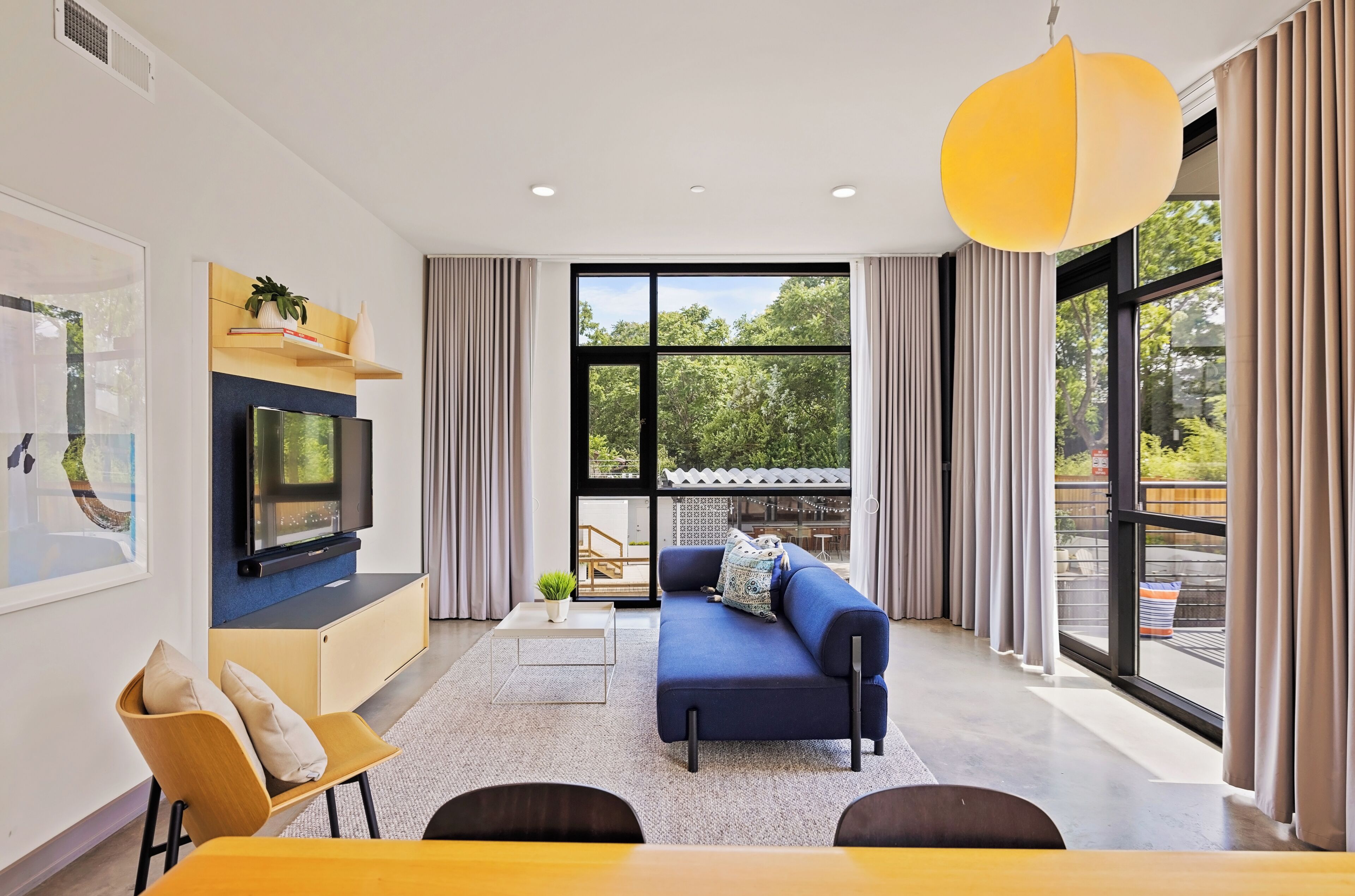 A modern living room with a TV, sofa, and dining area.