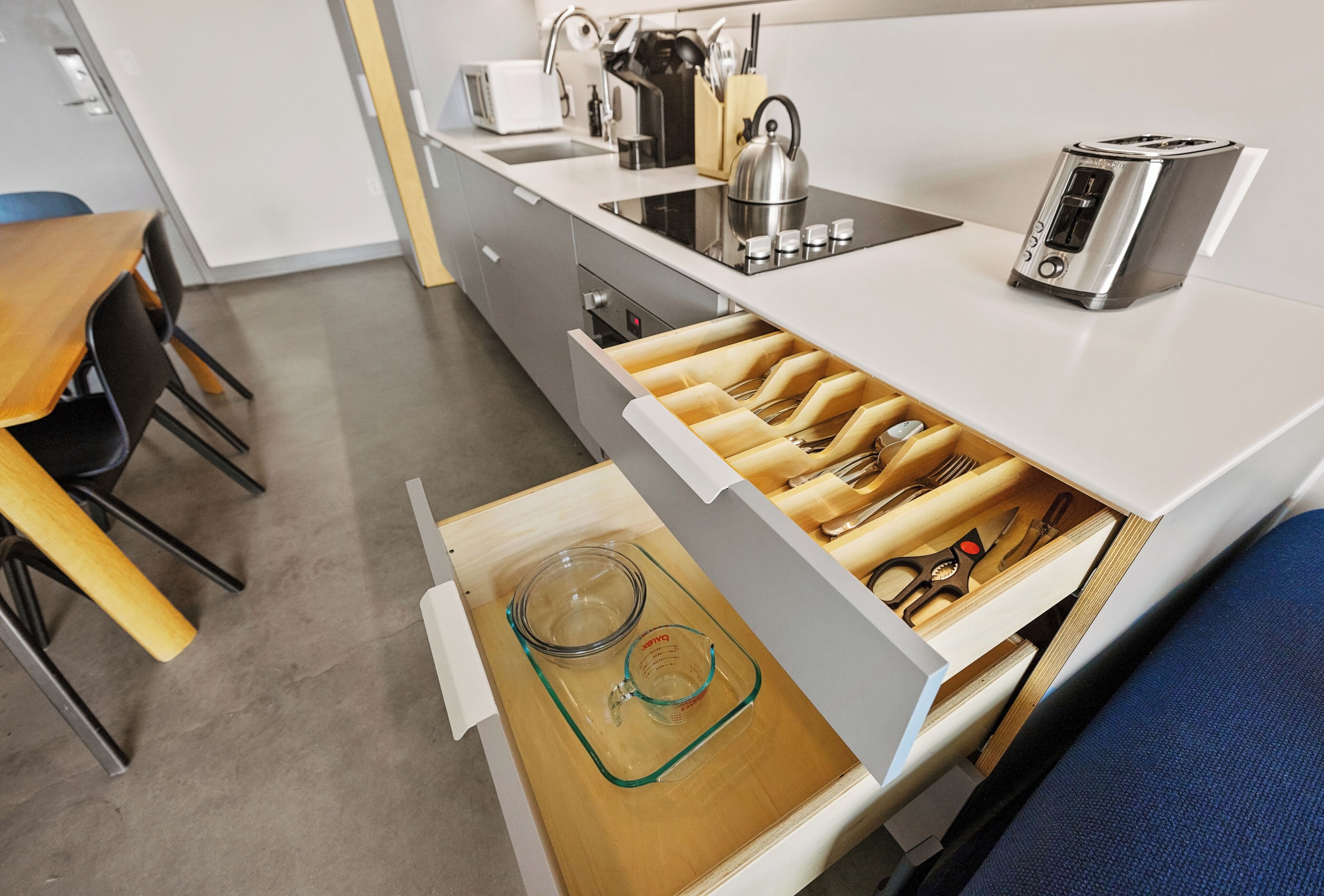 Une cuisine équipée d’un organiseur de tiroir, d’un grille-pain et d’une bouilloire.