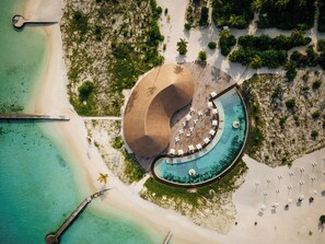 An aerial view of a resort with a large pool, beach, and palm trees. - Cinnamon Velifushi Maldives (Maldives Islands)