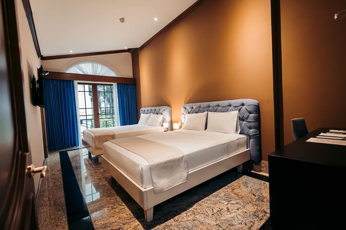 Ein modernes Hotelzimmer mit einem großen Bett, einem Schreibtisch und Blick ins Freie.