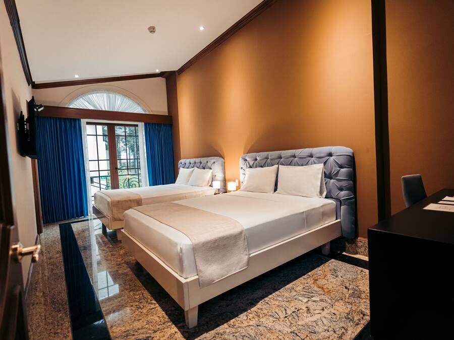 Una habitación de hotel moderna con una cama grande, un escritorio y vistas al exterior.