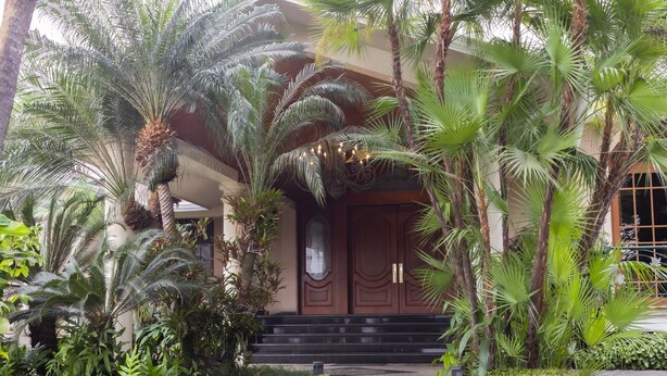 A building with a traditional architectural style, featuring a prominent entrance with a set of stairs leading up to a double door.