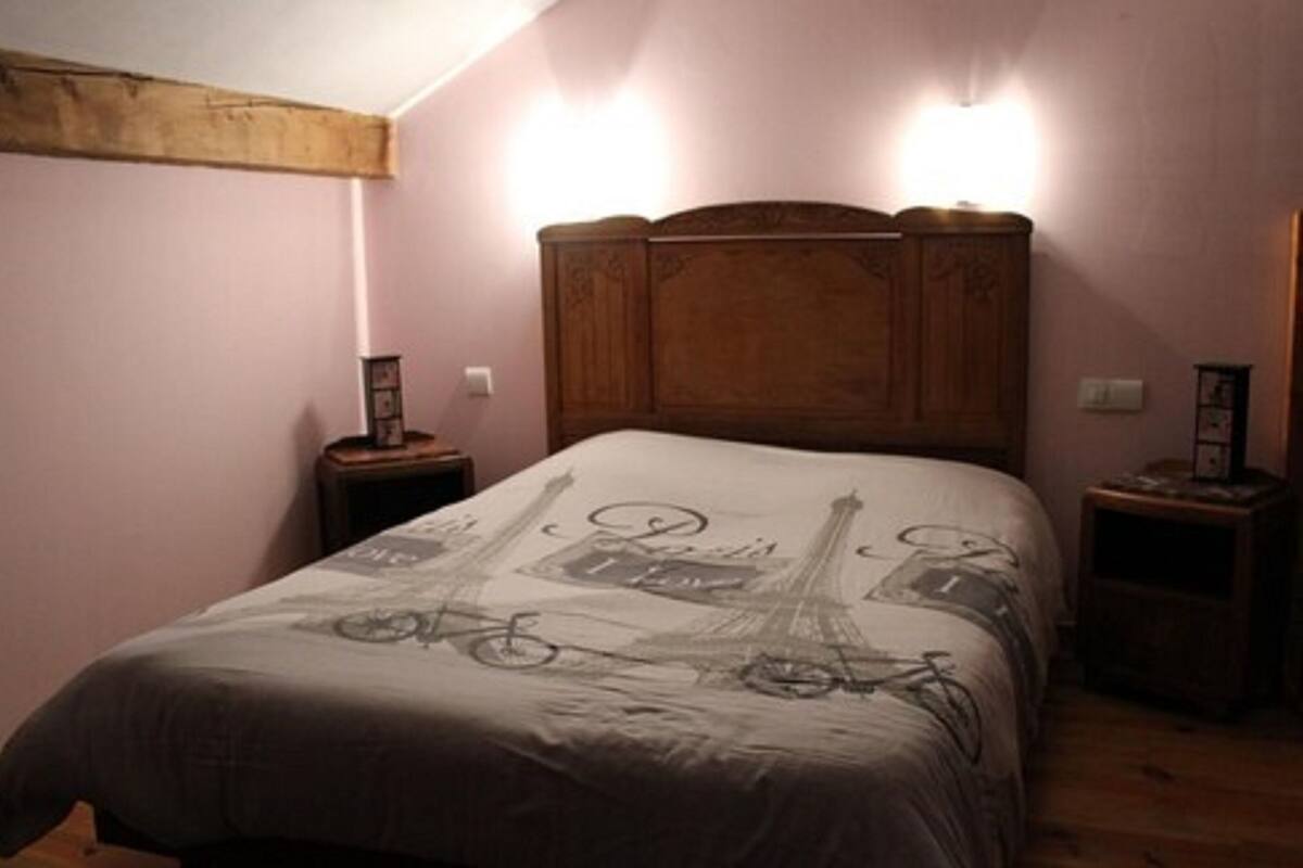 A bedroom with a bed, two bedside tables, and a nightstand.