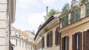 Una calle estrecha bordeada por edificios históricos con persianas y balcones uniformes.