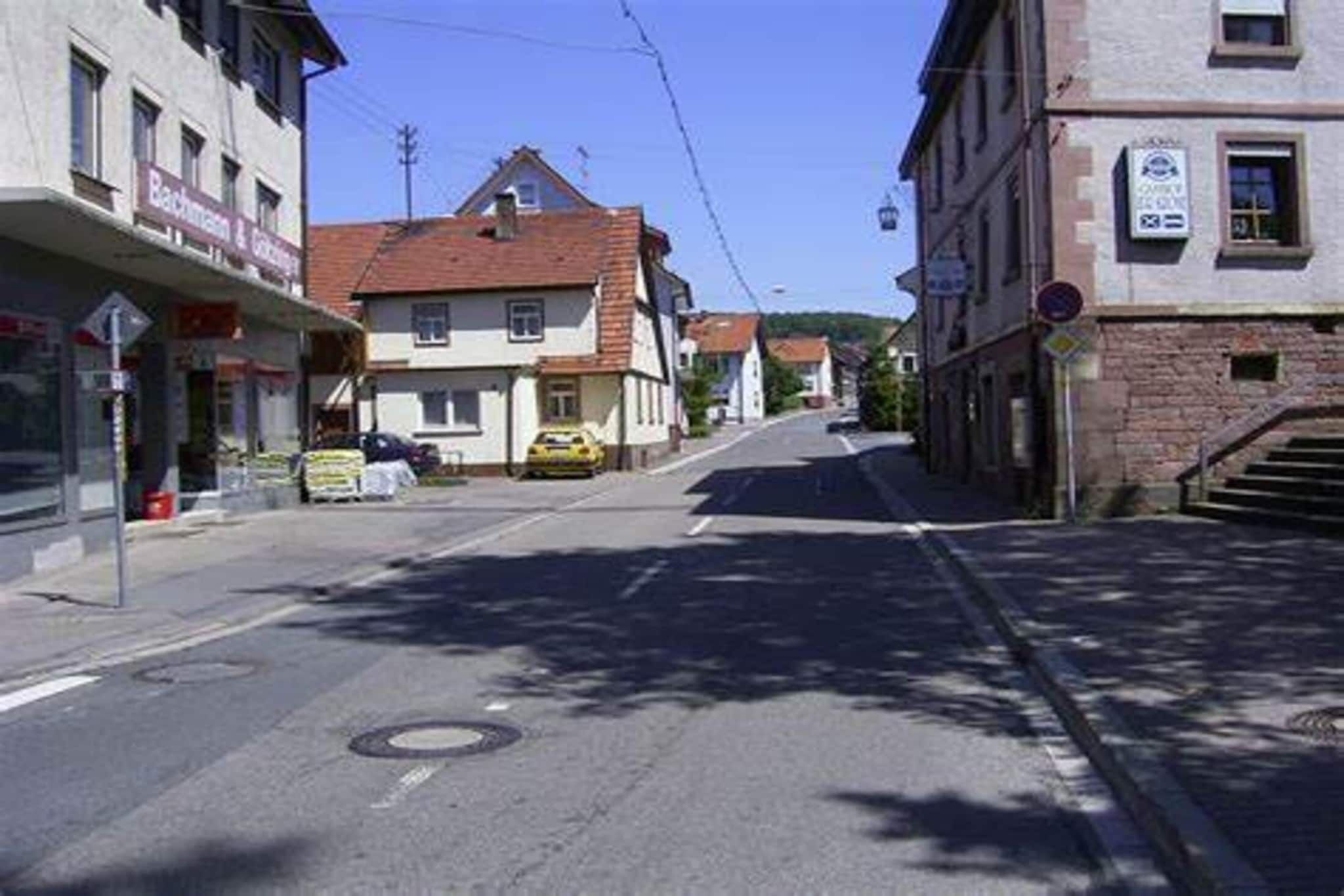 A street with buildings, a yellow car parked on the side, and a clear sky.