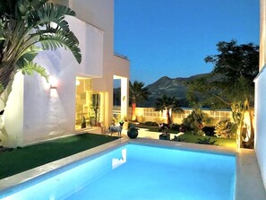 Un espace piscine moderne offrant une vue dégagée sur une montagne en arrière-plan.