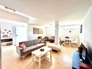 Ein modernes Wohnzimmer mit einer Couch, einem Couchtisch und einem Essbereich mit Stühlen und einem Tisch.