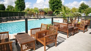 A poolside area with wooden lounge chairs and a pool. - Camping Haliotis (Pontorson)